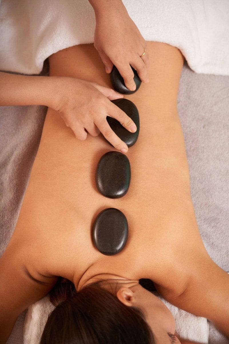 mujer-joven-masaje-terapia-piedras-calientes-salon-spa-scaled-e1712842322750 masaje con piedras calientes en moontaña-roja-playa blanca